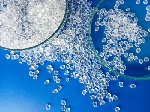 clear virgin plastic pellets scattered in a blue table